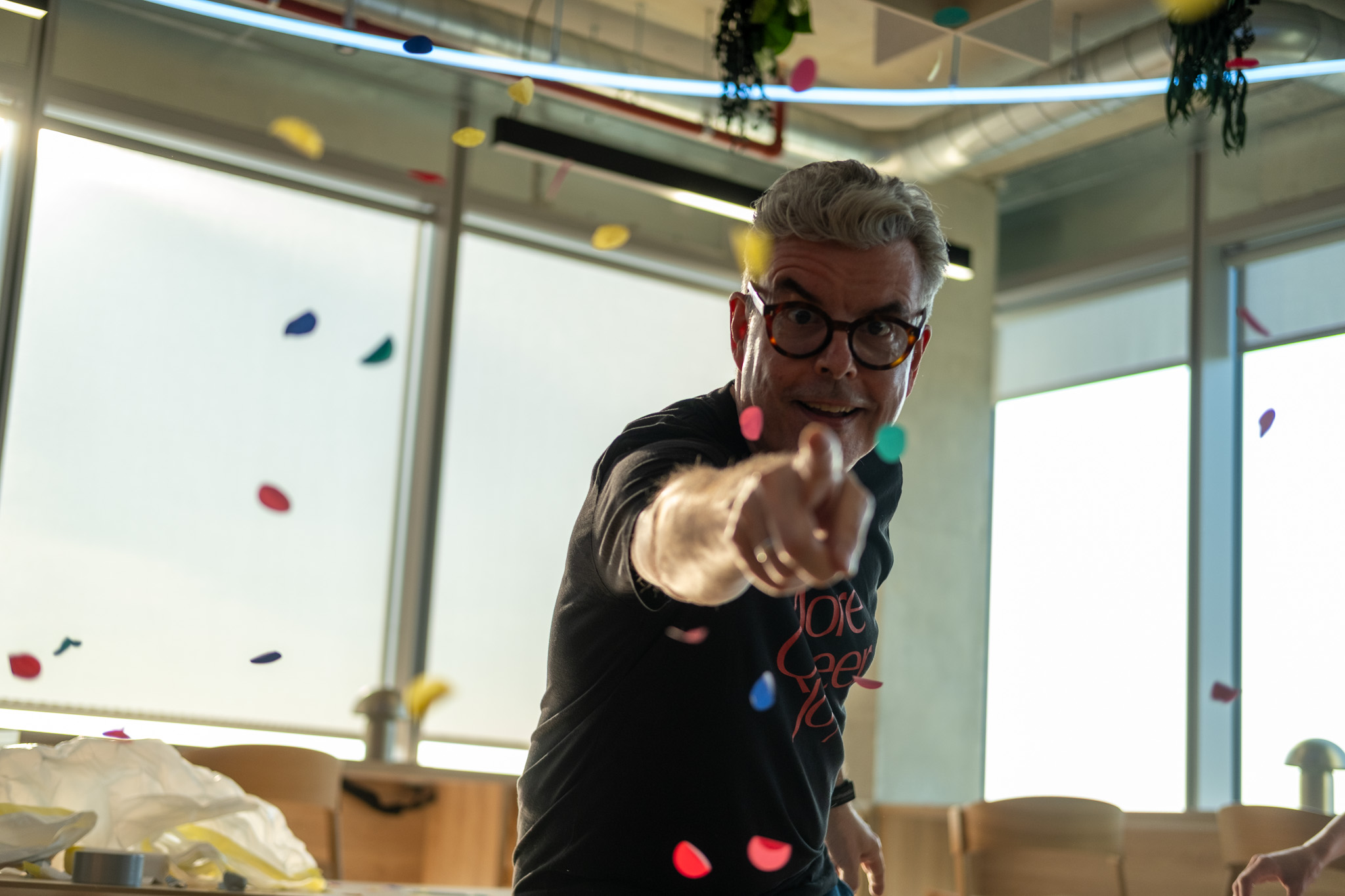 An audience at an event clapping and cheering enthusiastically. The crowd looks engaged, with some people laughing and smiling while applauding.