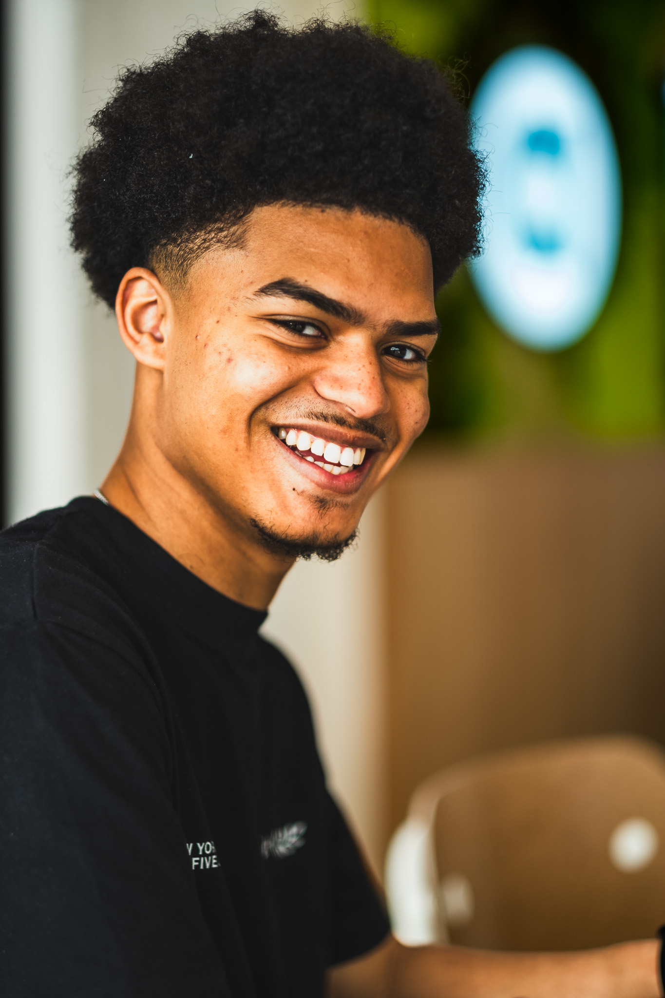 An audience at an event clapping and cheering enthusiastically. The crowd looks engaged, with some people laughing and smiling while applauding.