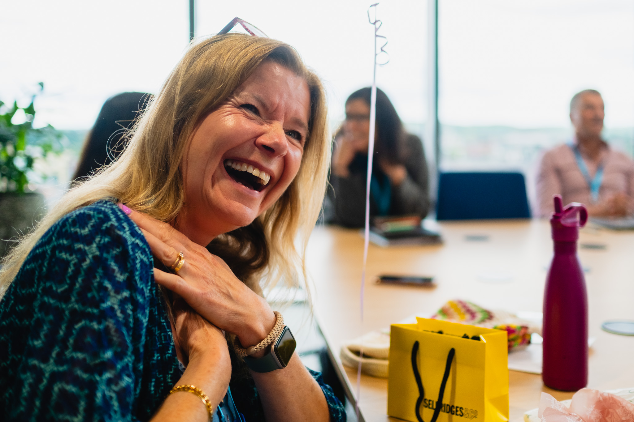 An audience at an event clapping and cheering enthusiastically. The crowd looks engaged, with some people laughing and smiling while applauding.
