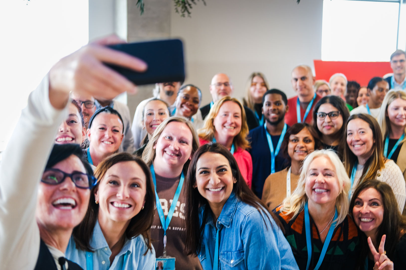 An audience at an event clapping and cheering enthusiastically. The crowd looks engaged, with some people laughing and smiling while applauding.