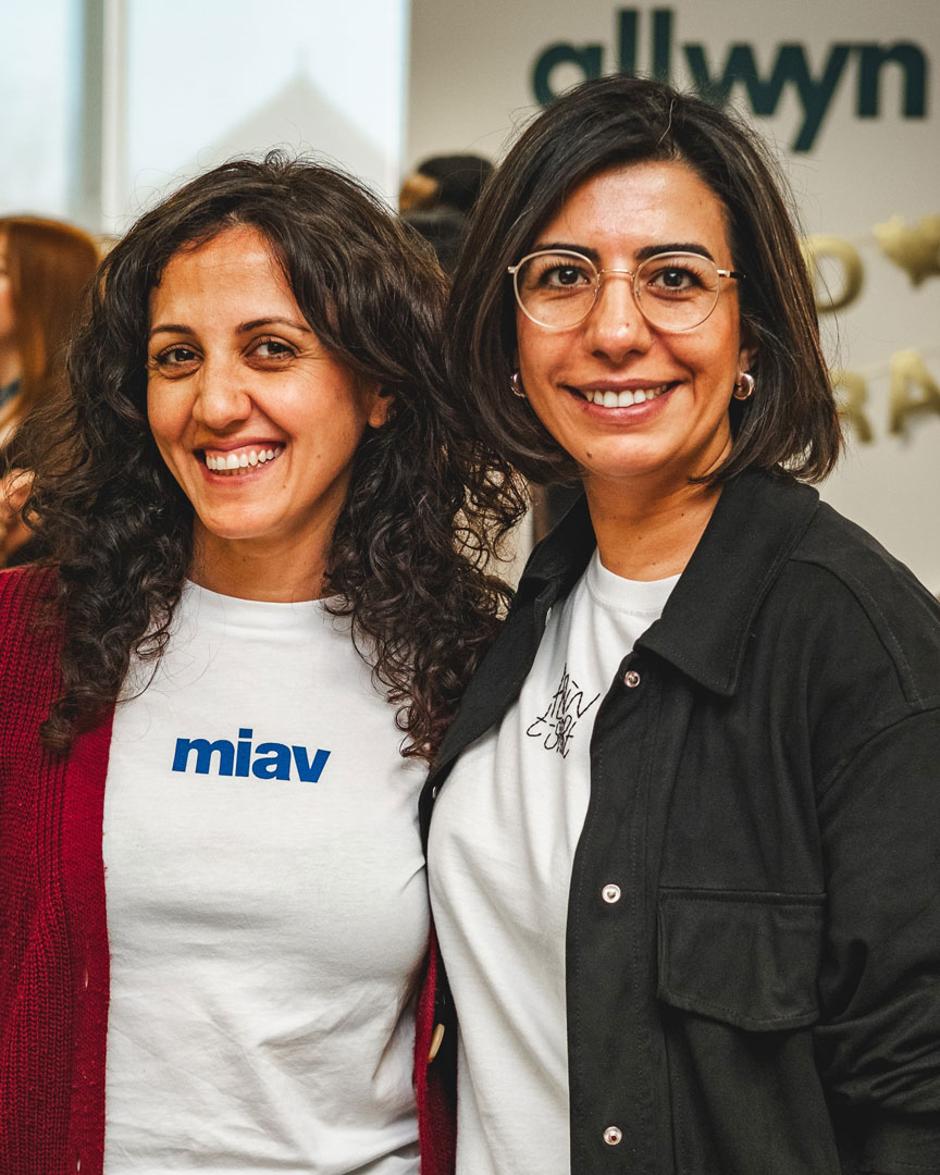 An audience at an event clapping and cheering enthusiastically. The crowd looks engaged, with some people laughing and smiling while applauding.