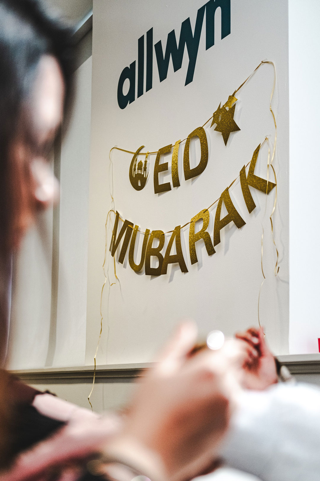 An audience at an event clapping and cheering enthusiastically. The crowd looks engaged, with some people laughing and smiling while applauding.