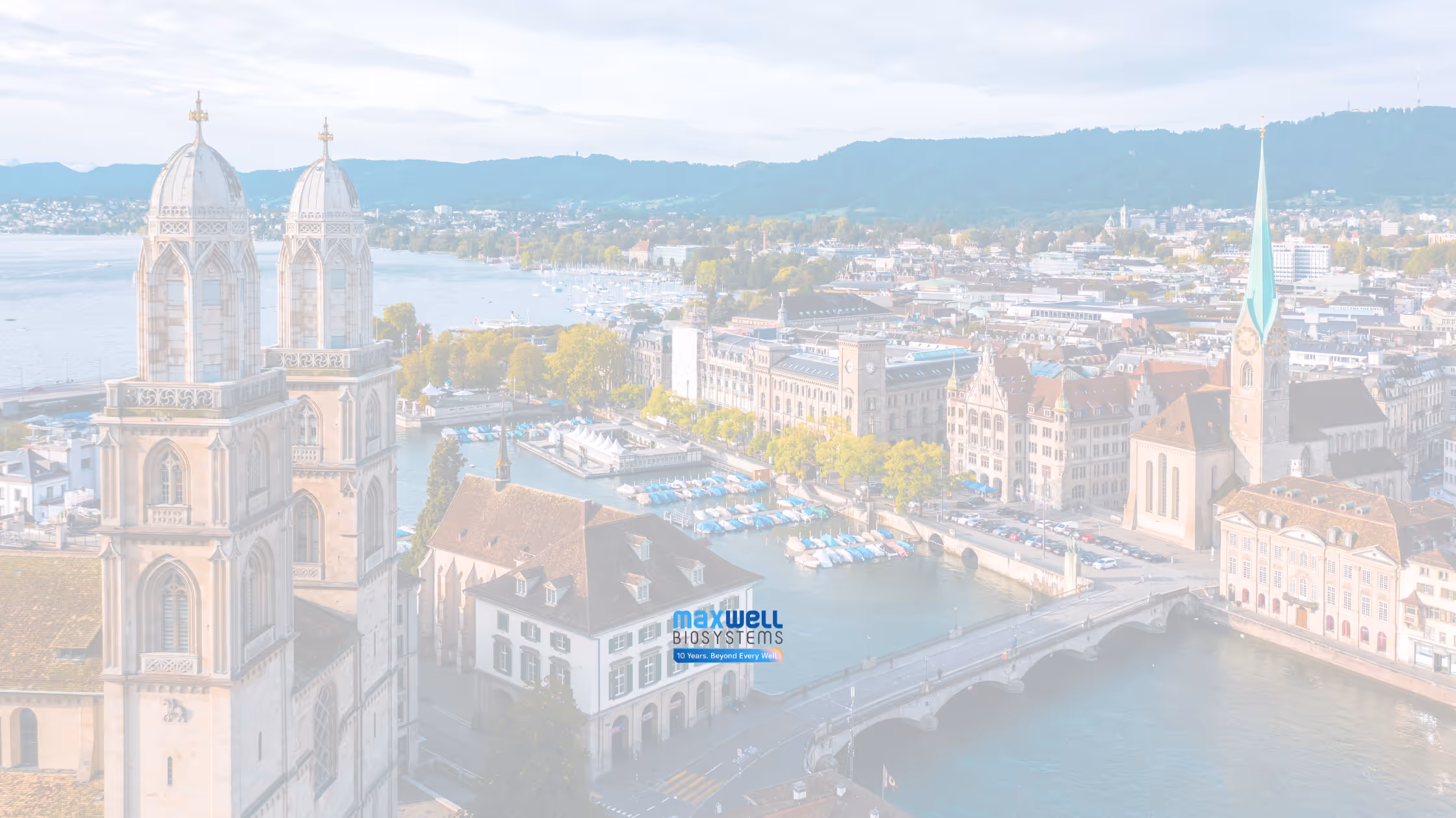 Aerial view of Zurich cityscape with the medieval St. Peter church clock tower and colorful riverside buildings along the Limmat River.