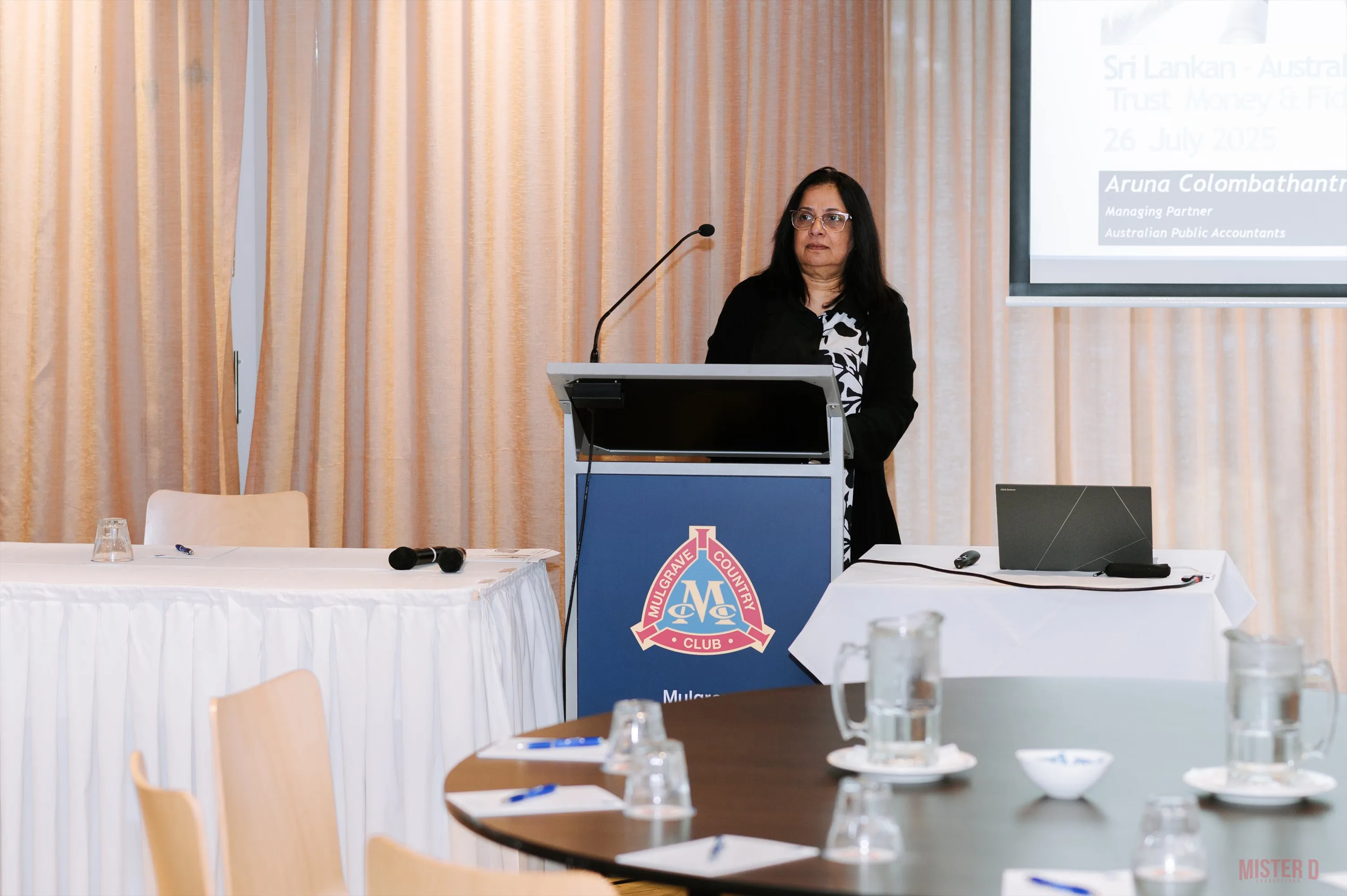 A speaker presenting at the podium in front of the SALA banner