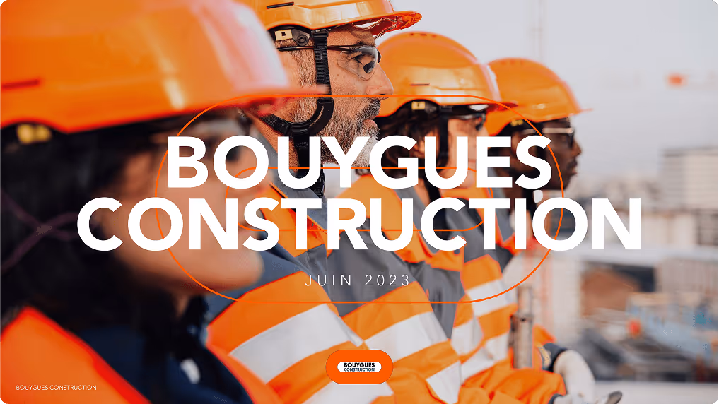 Quatre ouvriers de la construction en tenue de sécurité orange avec casques, regardant vers la droite sur un chantier, texte Bouygues Construction juin 2023 en superposition.