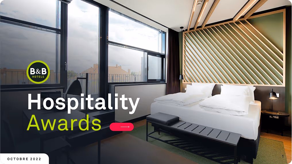 Chambre d'hôtel moderne avec un grand lit double, des fenêtres lumineuses et un décor en bois géométrique, texte Hospitality Awards et logo B&B Hotels.