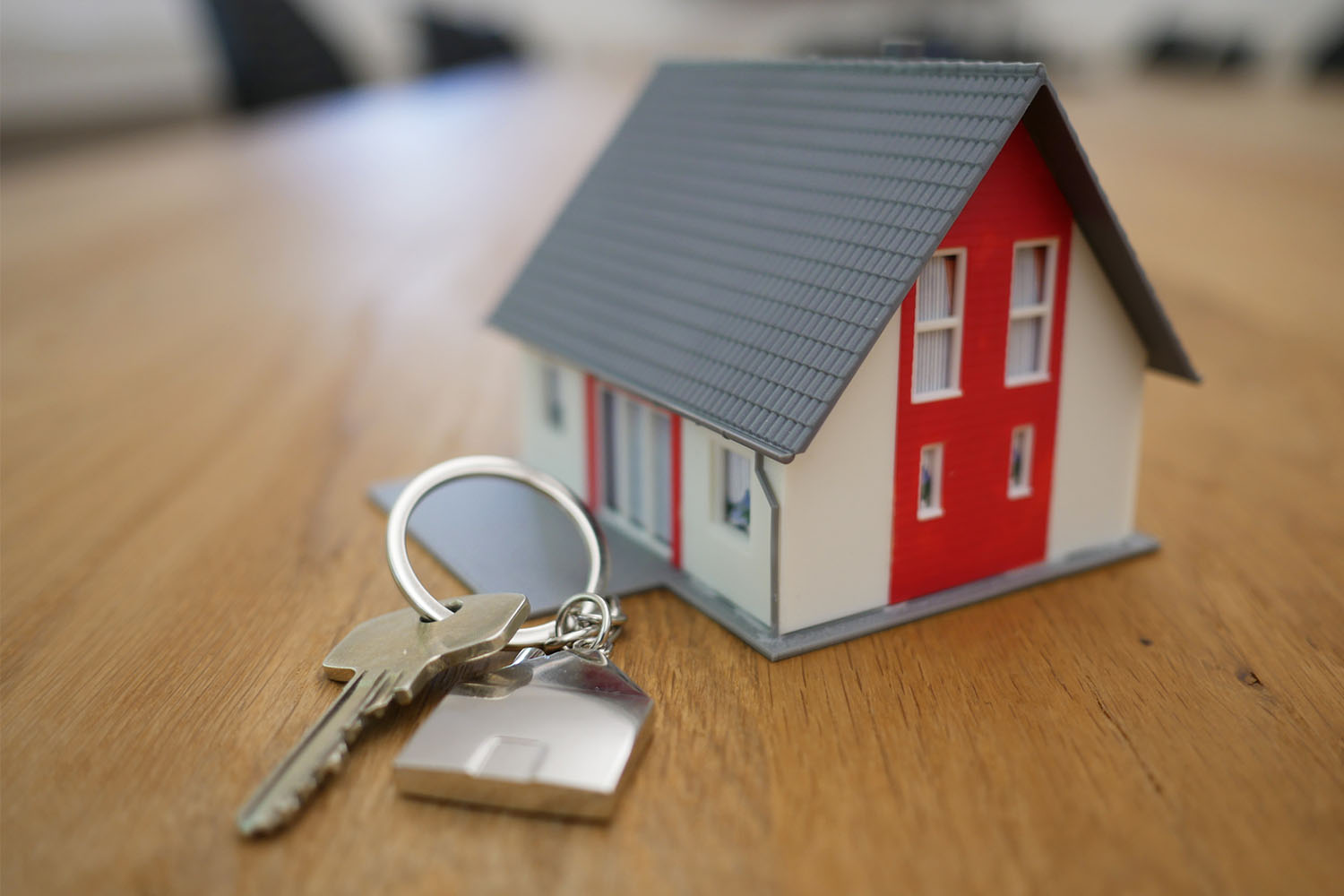 A model of a tiny house next to a set of house keys
