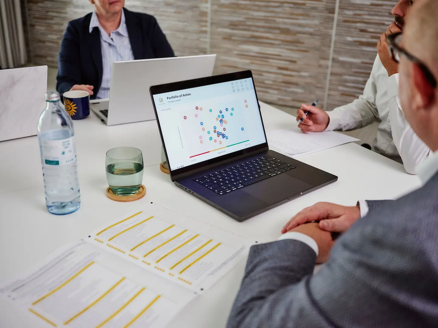 Some people from the EUCUSA team sitting at a meeting table and looking at a portfolio of actions.