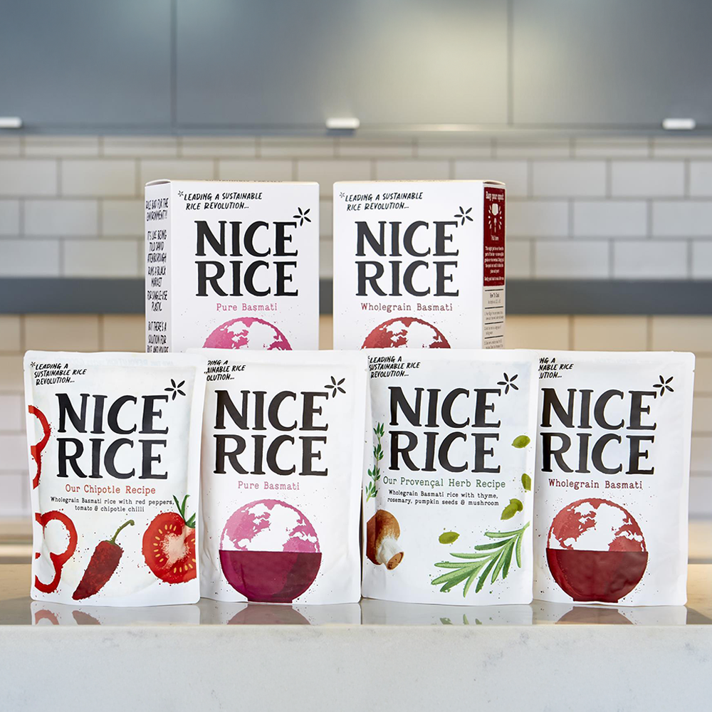 6 packages of Nice Rice stacked on a kitchen counter. 
