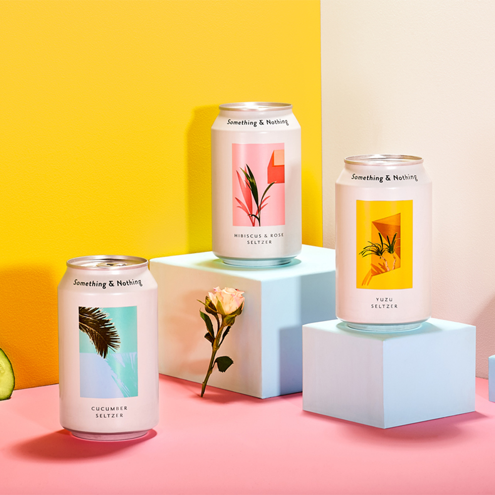 A curation of Something & Nothing cans on a colourful pink and yellow background.