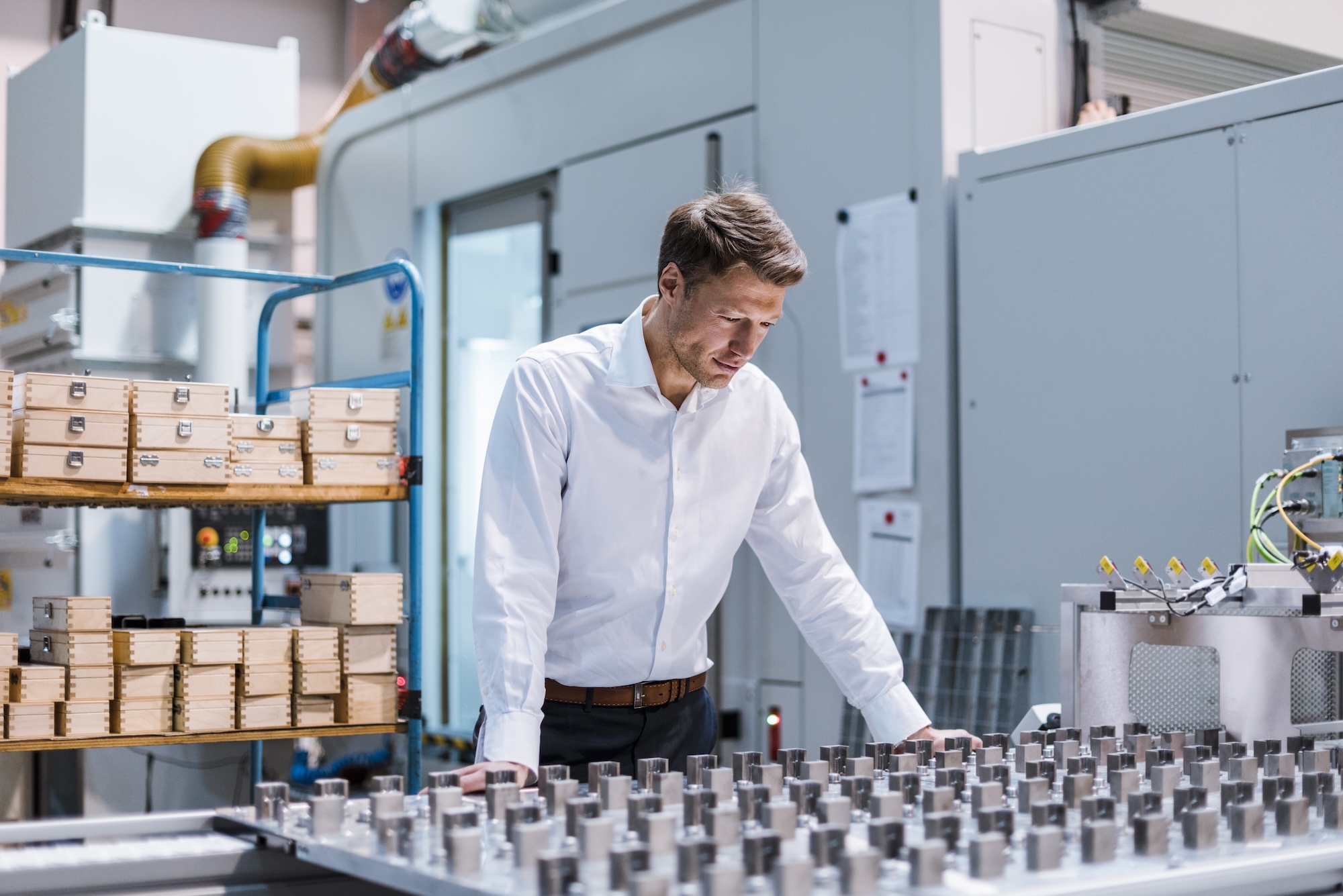 Geschäftsführer eines mittelständischen Betriebs sieht besorgt auf seine Produktion