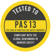 Kulatá žlutá pečeť s nápisem TESTED TO PAS 13 a textem o shodě s globálním standardem bezpečnostních bariér.
