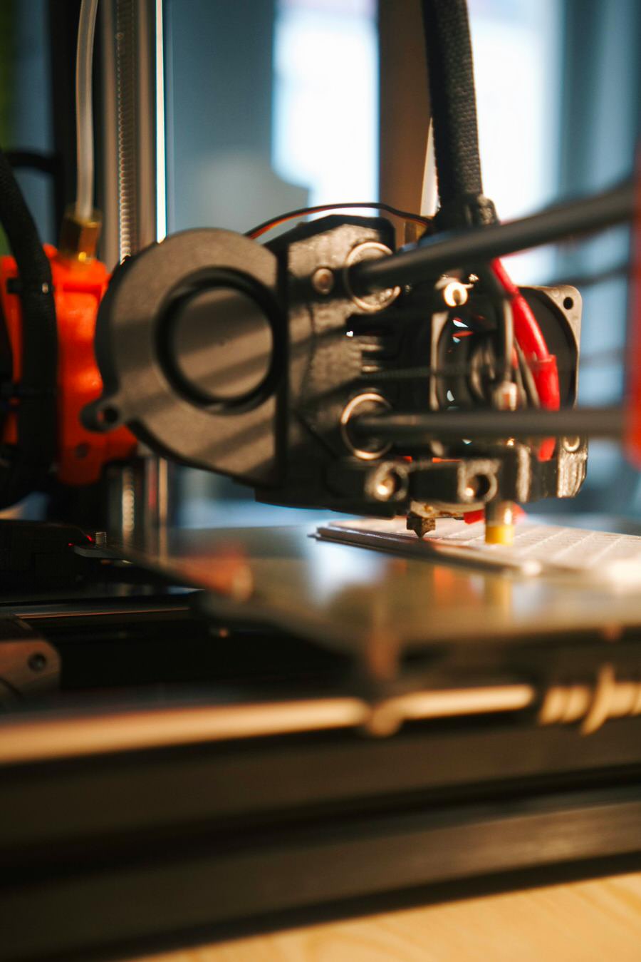 A 3D printer in operation, producing a component.