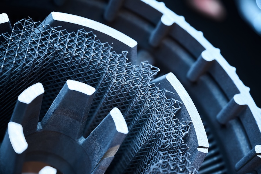  Close-up of metal additive manufacturing component featuring intricate 3D-printed lattice structure between served blades.