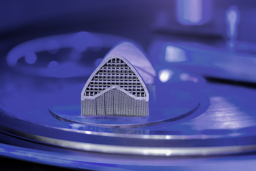  Close-up of metal additive manufacturing component featuring intricate 3D-printed lattice structure between served blades.