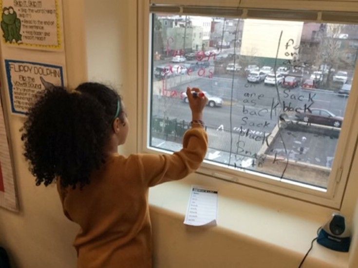 Children drawing on a window