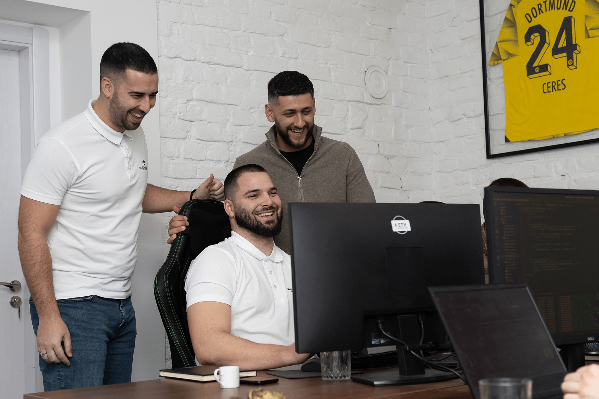 Software Engineers looking at a computer screen and smiling