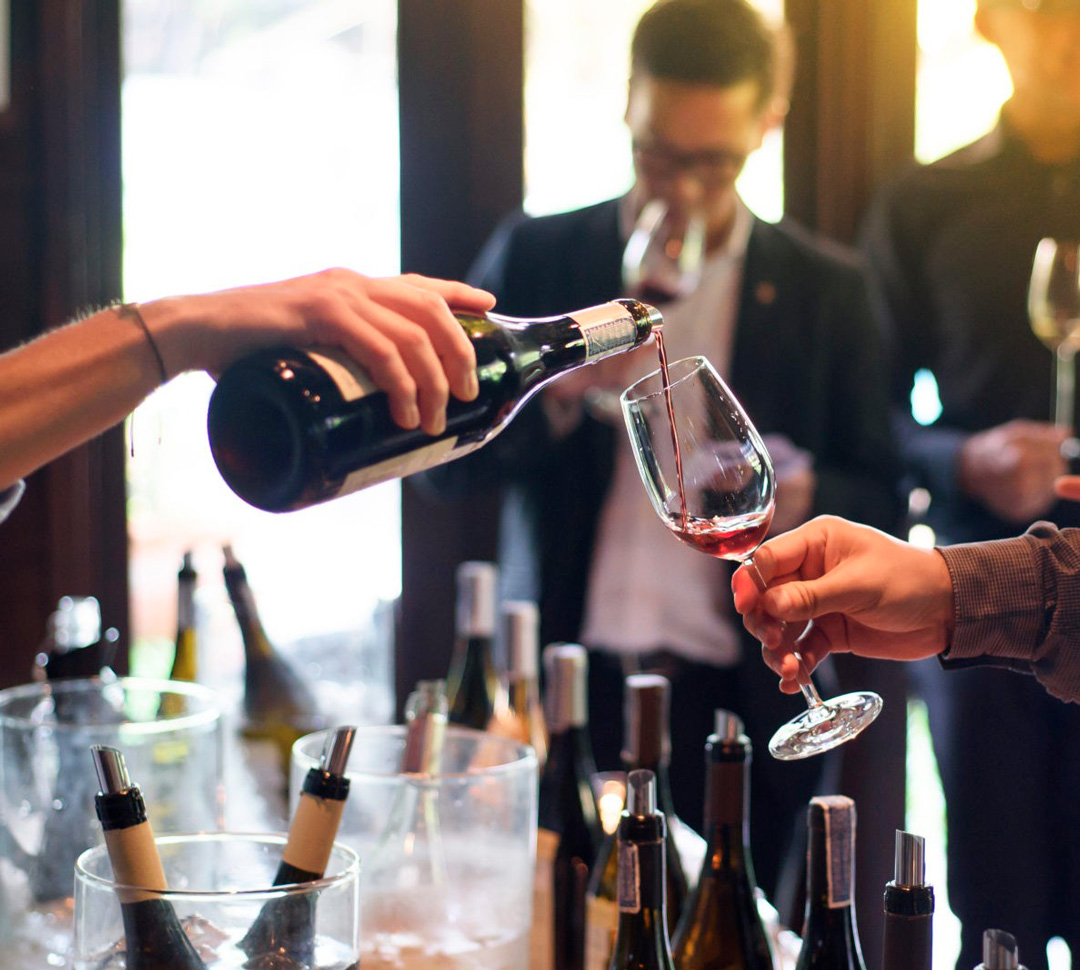 Professionals tasting wine side by side at a trade event
