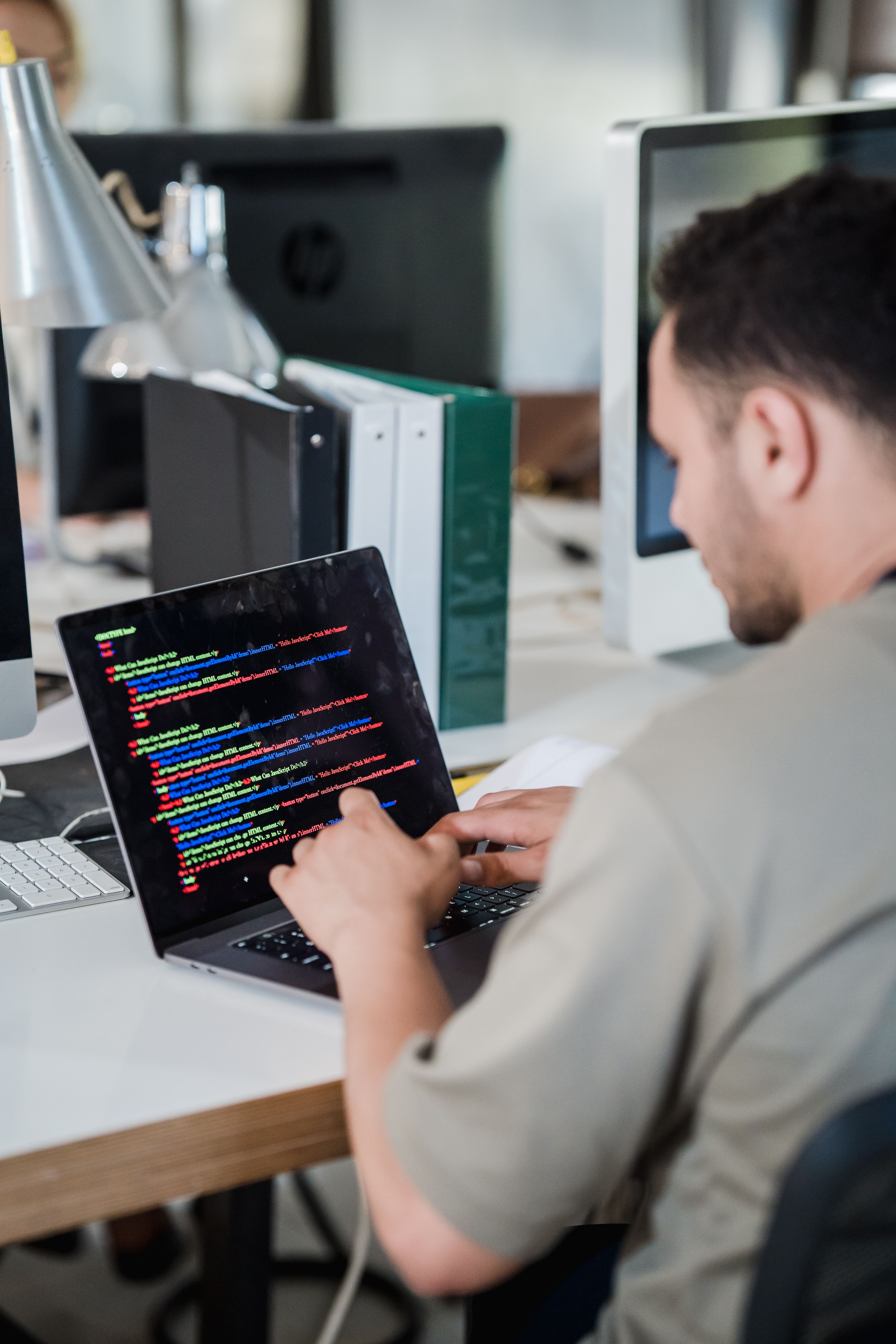 Développeur travaillant sur du code en open space, profil de cadre de la tech visé par le PER et le Girardin