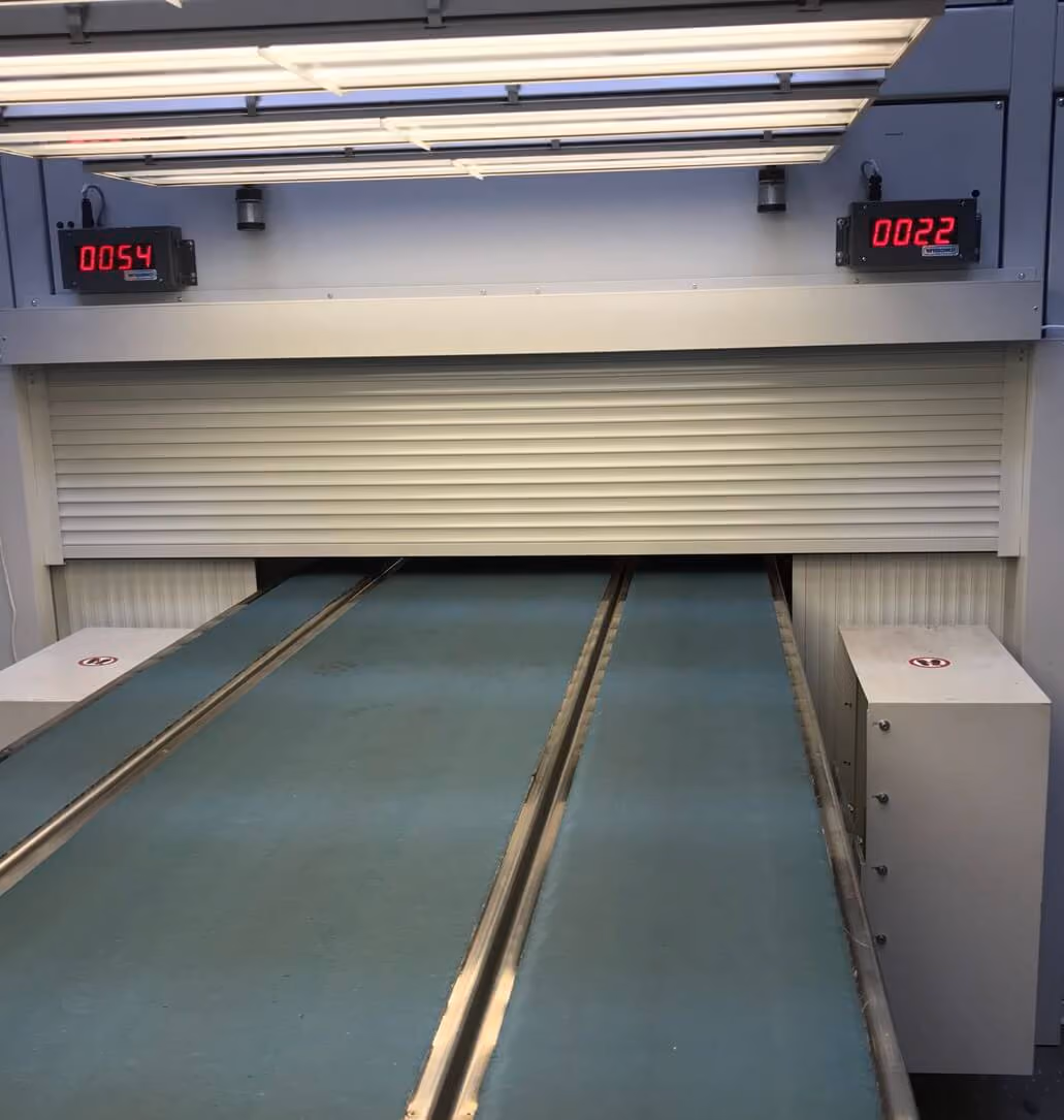Frontalansicht einer Industrieanlage mit weißem Rollladen und zwei parallelen Führungsschienen