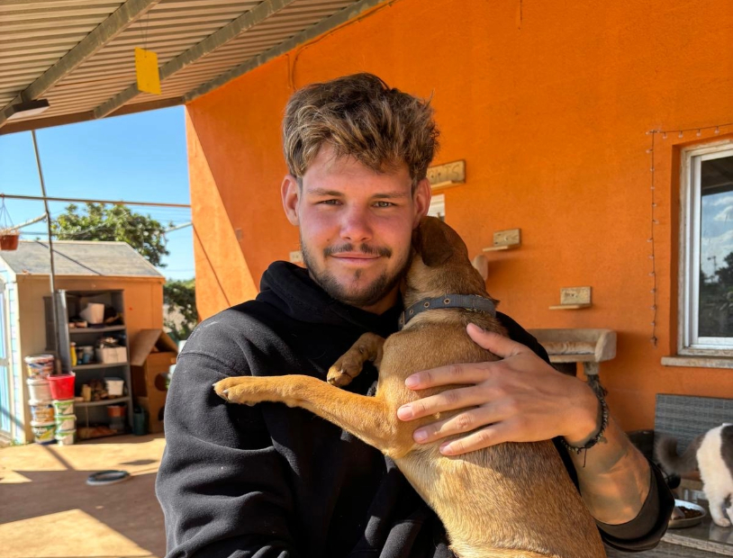 Dominic, founder of Back to Earth, cuddling a rescued cat at the Better Life for Cats shelter