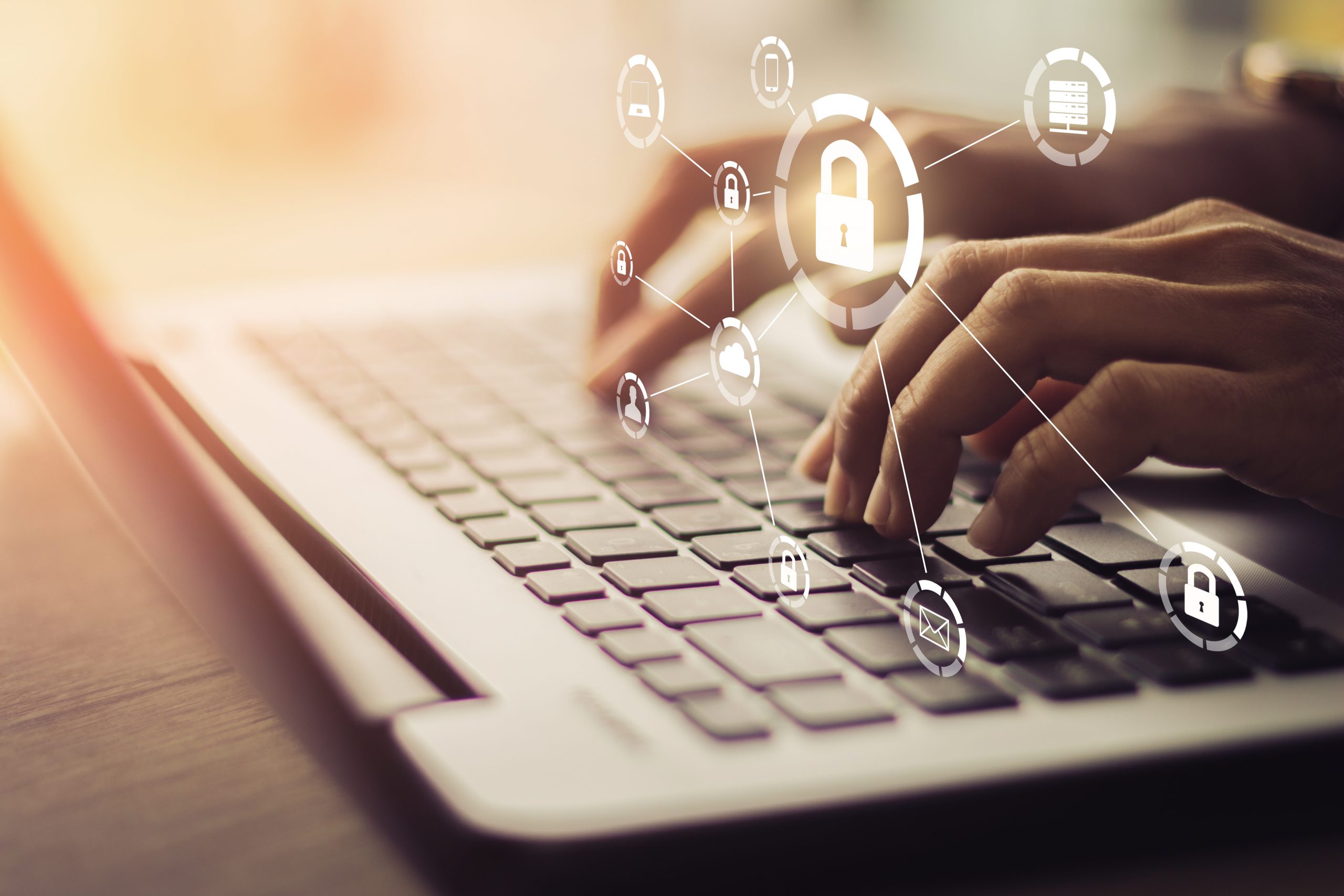 Hands typing on laptop with cybersecurity icons
