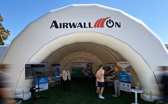 AirWallOn branded inflatable tent with people inside at an outdoor exhibition event.