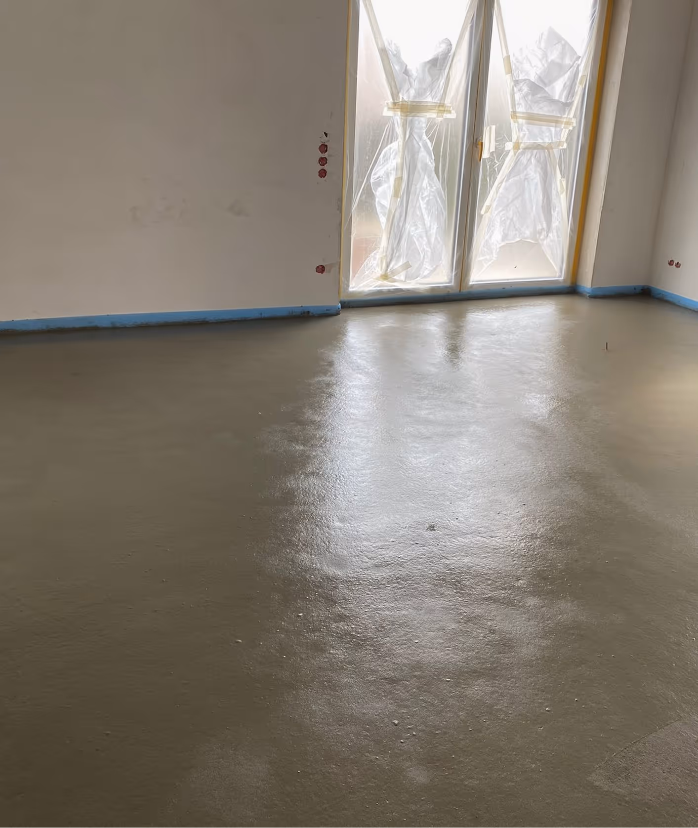 Frisch geglätteter Zementestrich in Wohnraum mit Tageslicht – AG Estriche Heilbronn