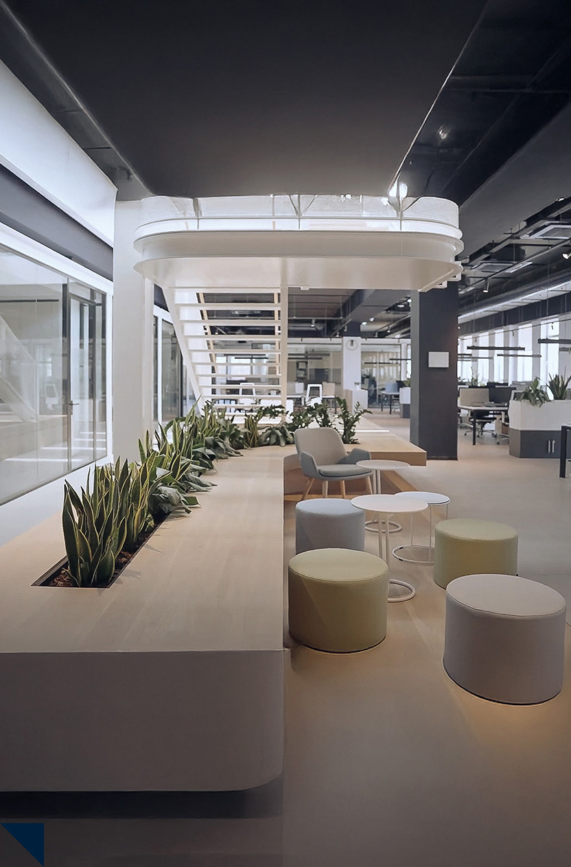 Modern office interior with a curved planter filled with green plants, round cushioned stools, armchairs, and white tables under a black ceiling.