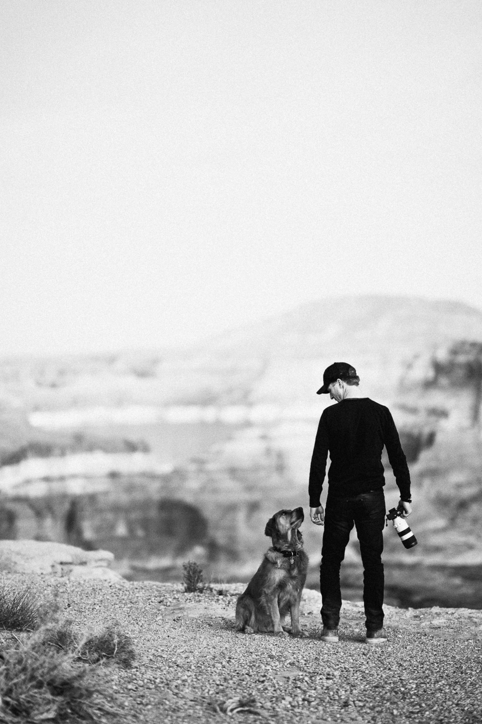 Man and dog standing near overlook in Utah