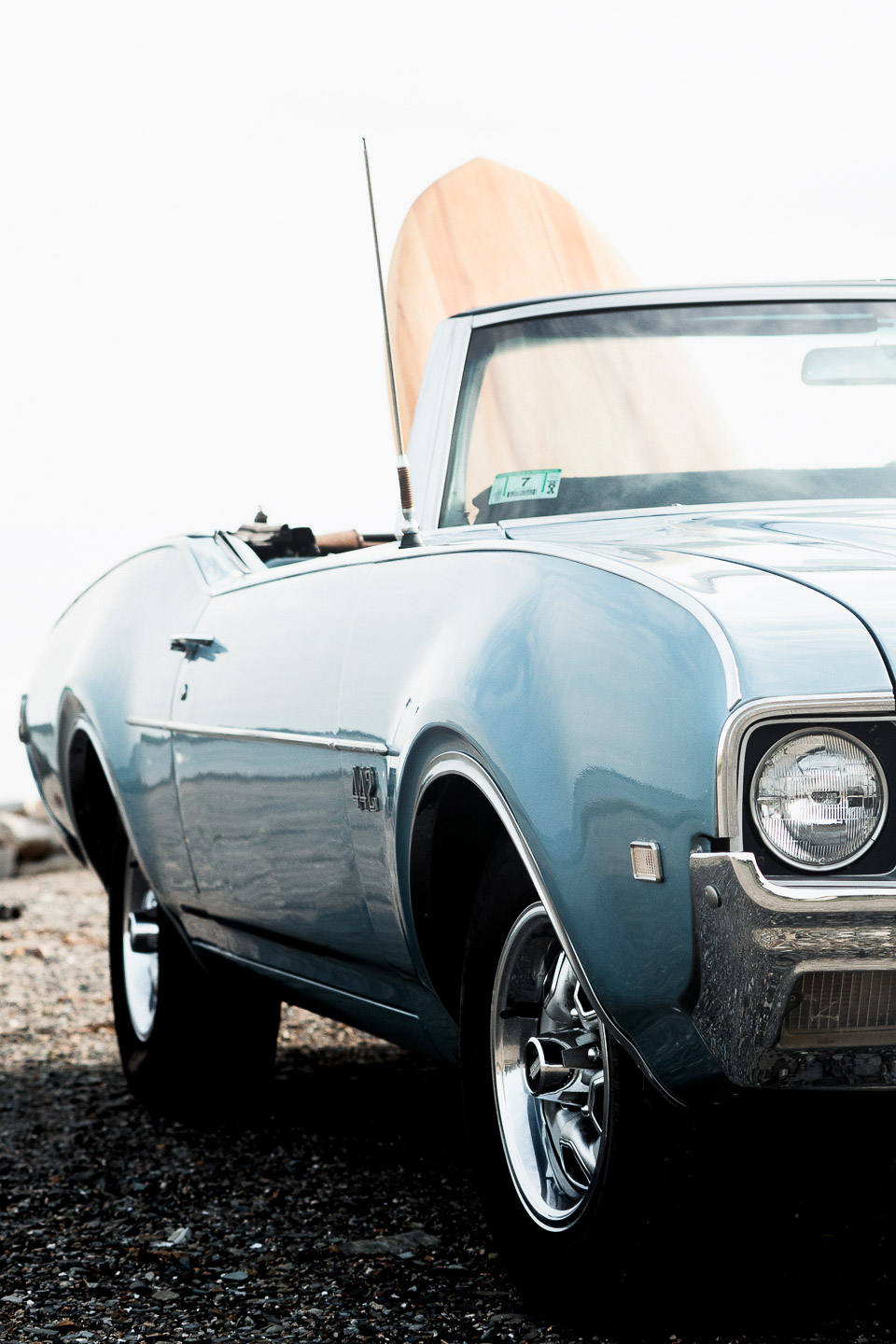 Wooden surfboard in a classic car