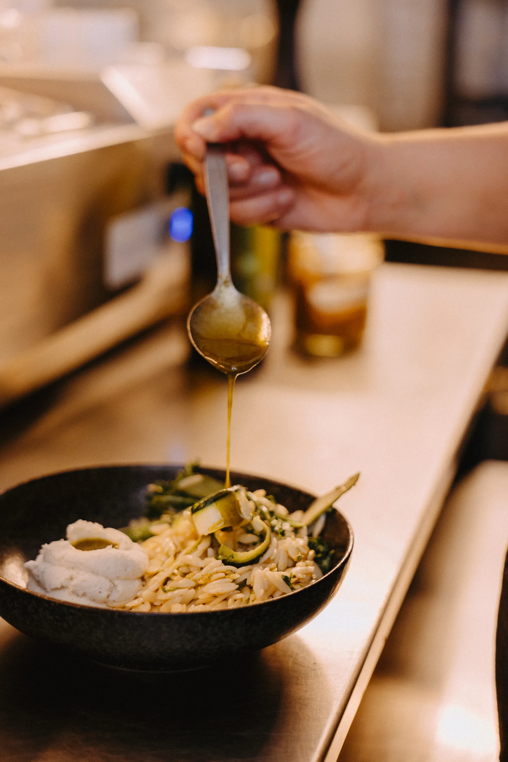 A dish being prepared in the kitchen with oil poured upon