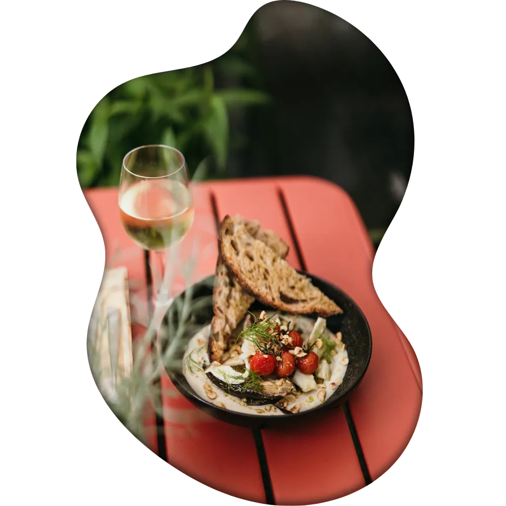 A seasonal dish on the red table on the terrace with a glass of white wine