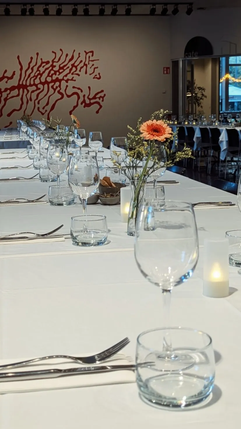 The whole restaurant where the table is set for a more formal event with white tablecloth and floral decorations