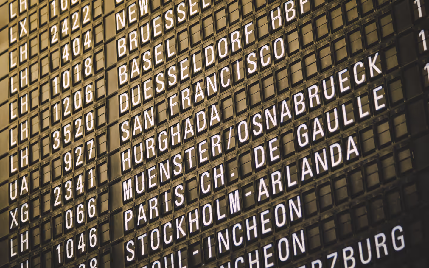 Close-up view of an airport departure board showcasing various international destinations.