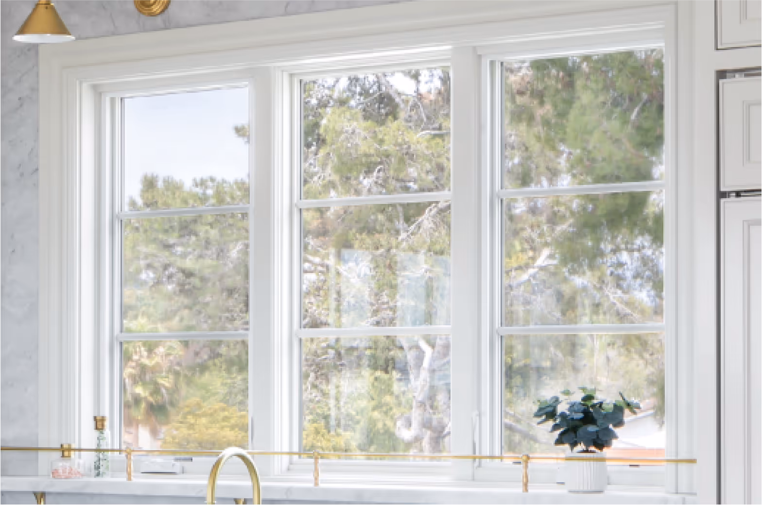 A photo of 3 windows above a sink in a kitchen.