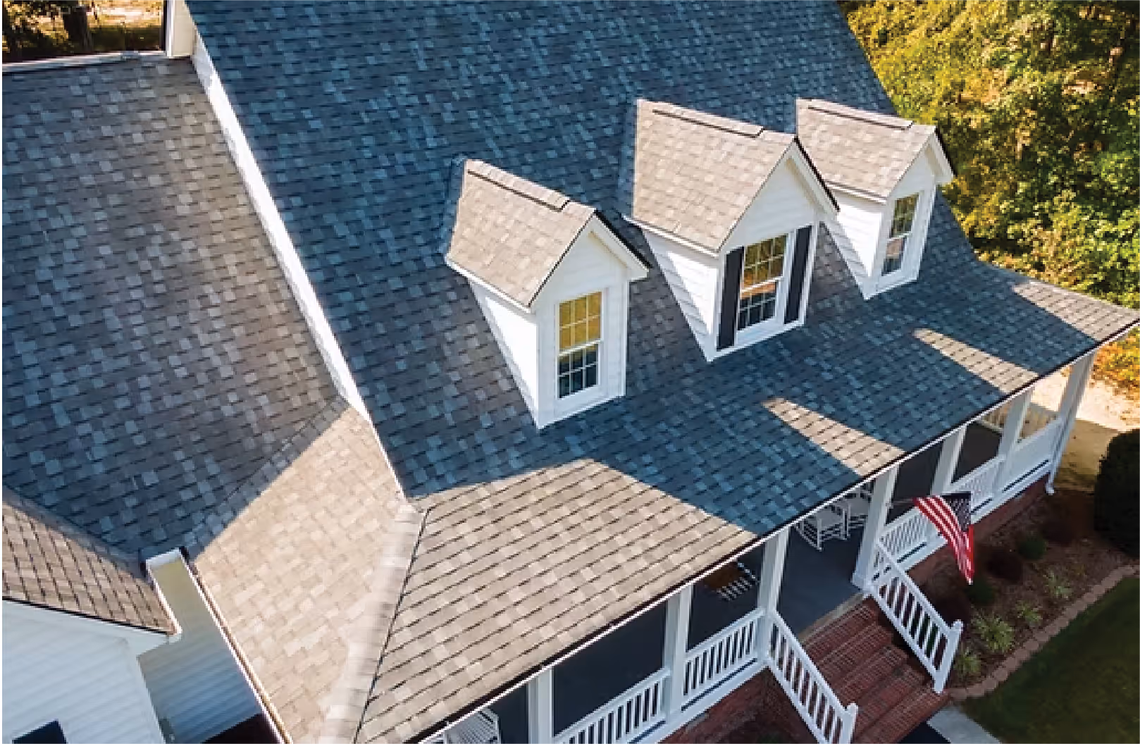A sky-view photo of a large house and it's roof.