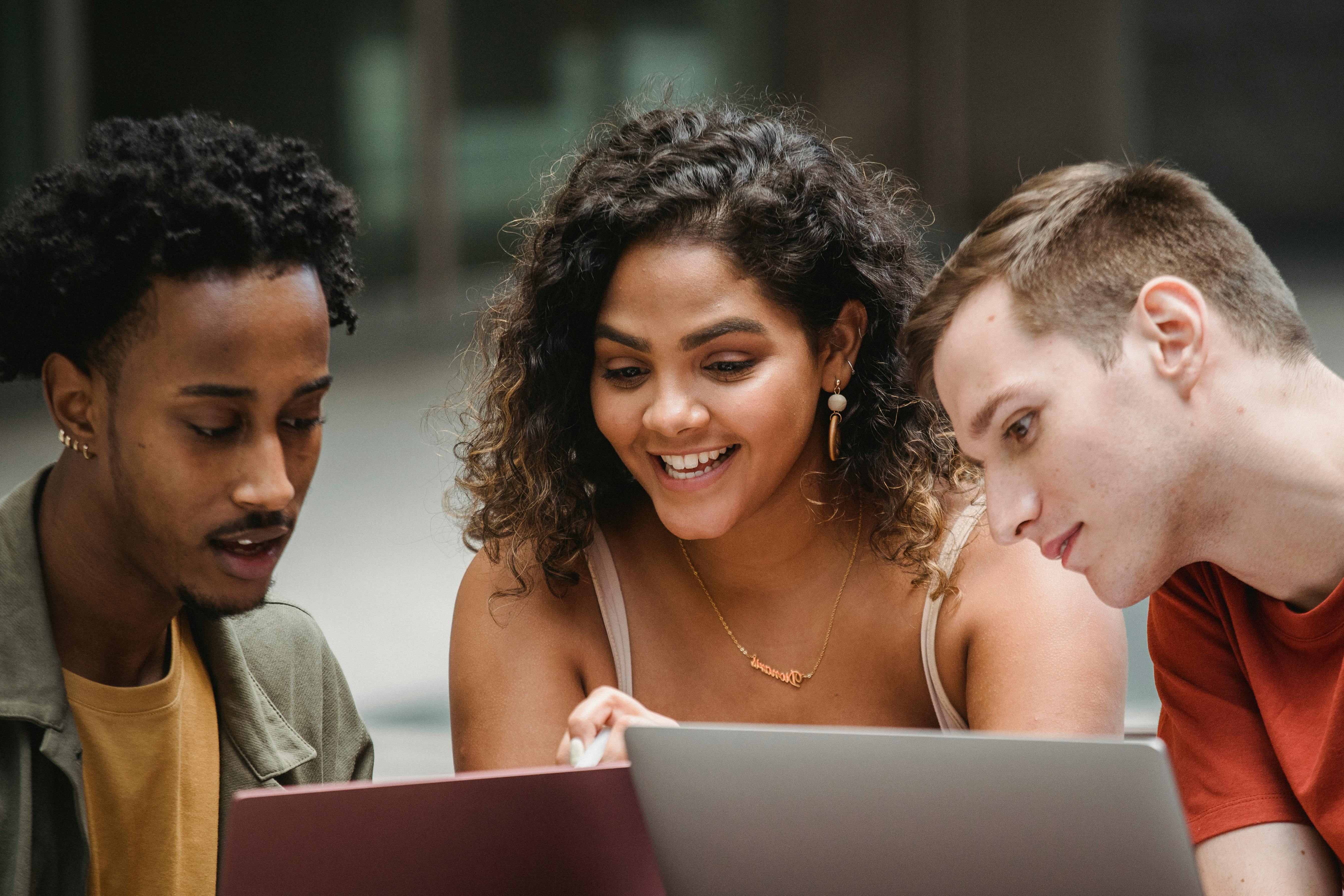 International students looking at laptops outside German university