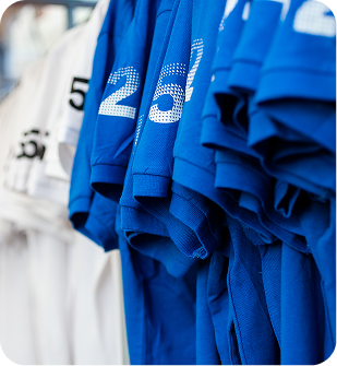 Close-up of hanging sports jerseys in blue and white with visible numbers 25 and 5.