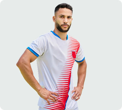 Man with a beard wearing a white and red sports jersey with hands on hips against a light background.