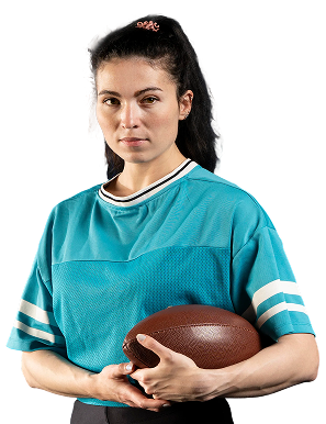 Young woman in a teal sports jersey holding a brown football and looking confidently at the camera.