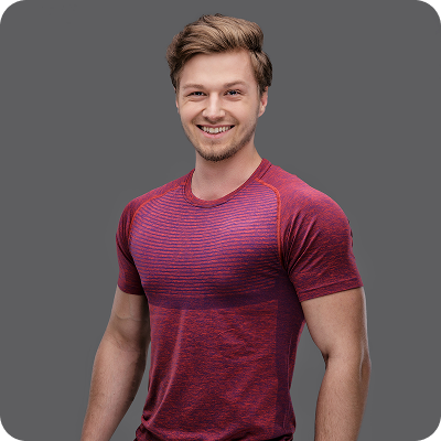 Smiling young man with light brown hair wearing a fitted red and purple striped athletic shirt against a gray background.