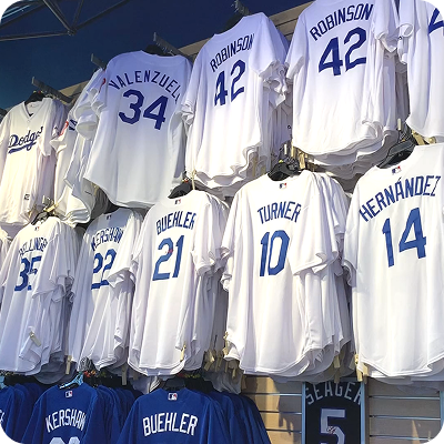 Display of Los Angeles Dodgers baseball jerseys with names and numbers including Robinson 42, Valenzuela 34, Buehler 21, Turner 10, and Hernández 14.