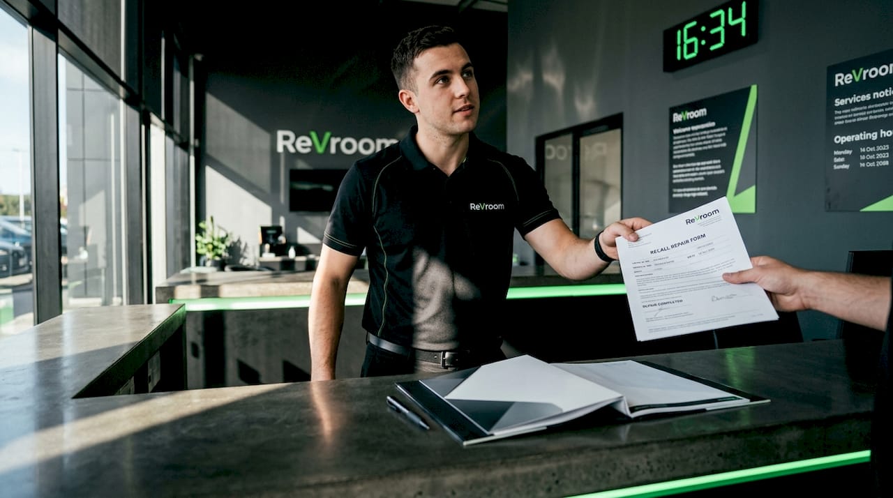 Service advisor giving customer recall repair document