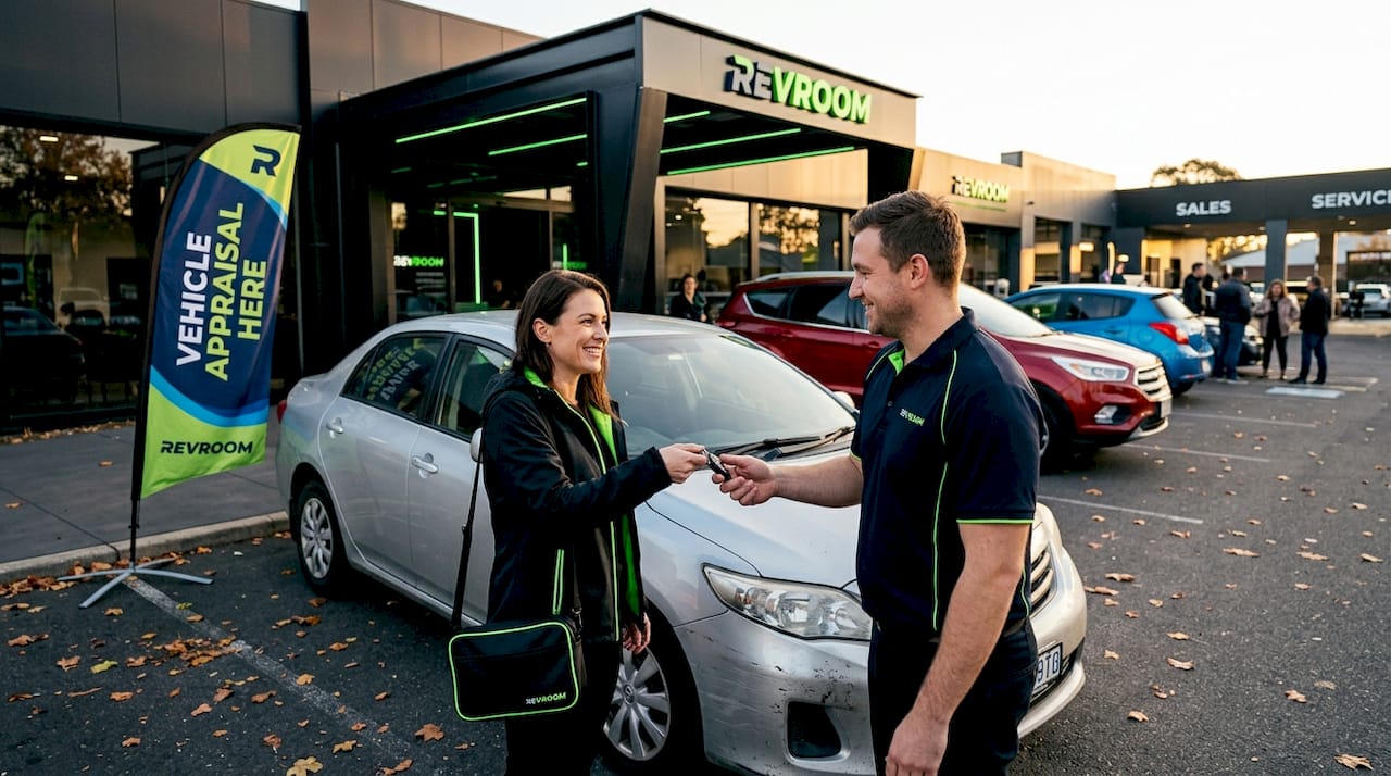 Woman hands car keys to dealership appraiser