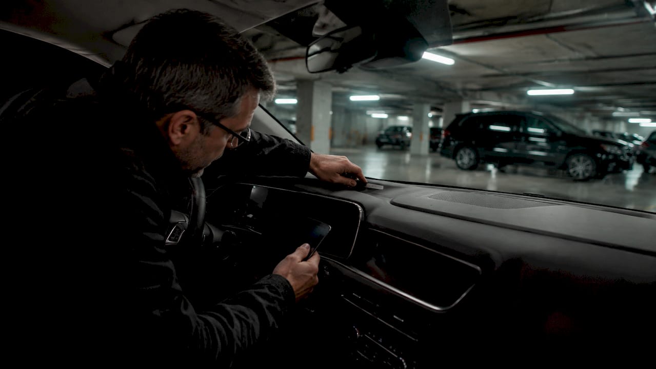 Man inspecting car VIN plate with smartphone
