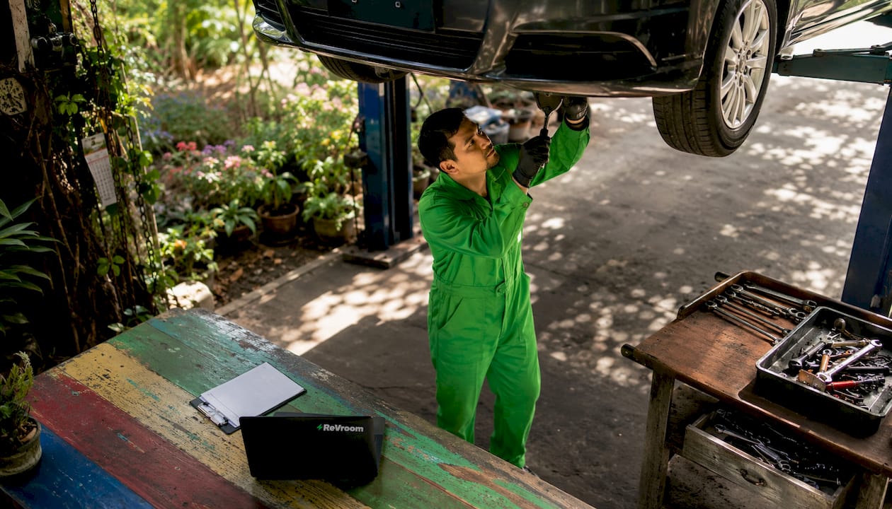 Mechanic inspecting rebuilt car undercarriage