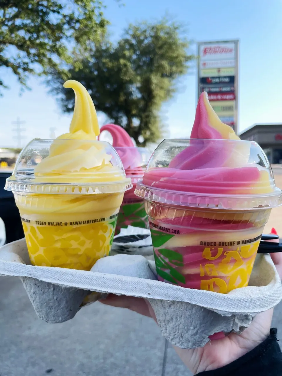 A picture of four Dole Soft Serves in a drink carrier. One of the Dole Soft Serves is a swirled.