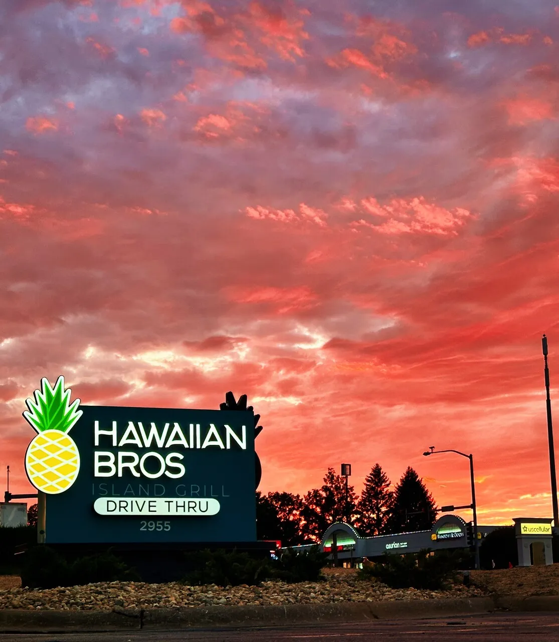 A picture of Hawaiian Bros sign at sunset.