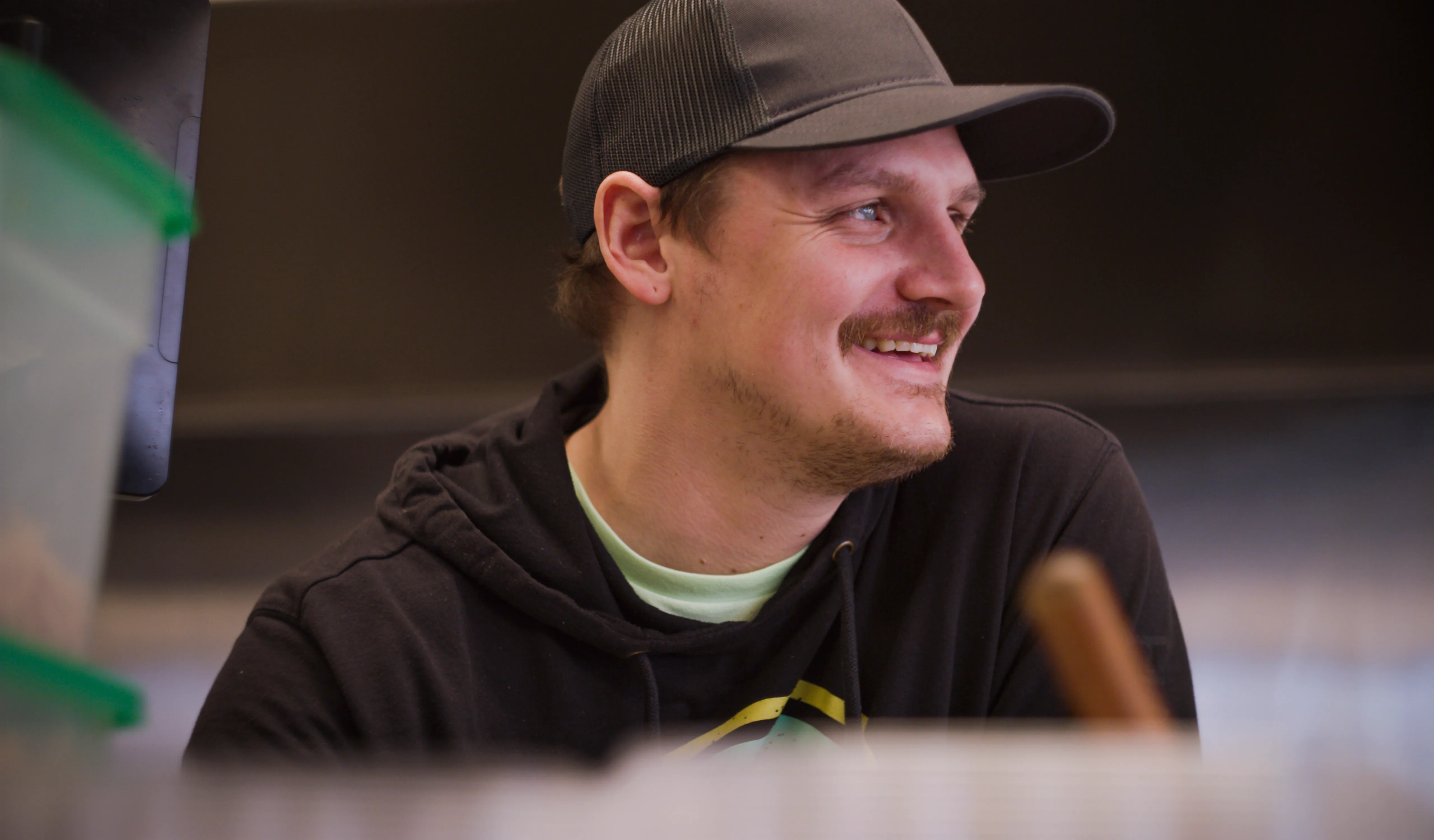 A smiling Hawaiian Bros cook behind the food service counter. 